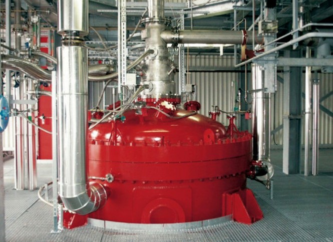 Kovová retorta pro nízkoteplotní pyrolýzu vstupní suroviny (a) a vertikální reaktor pro vysokoteplotní pyrolýzu vznikající směsi horkých plynů (b)